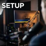 Live setup with microphones, monitor, and broadcast lighting.